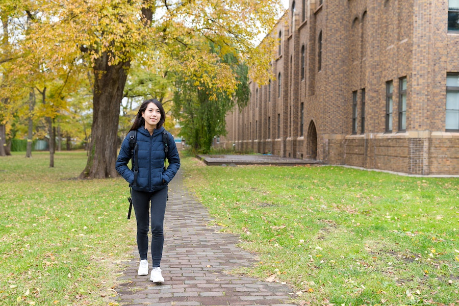 Student walking to class on a college campus pathway