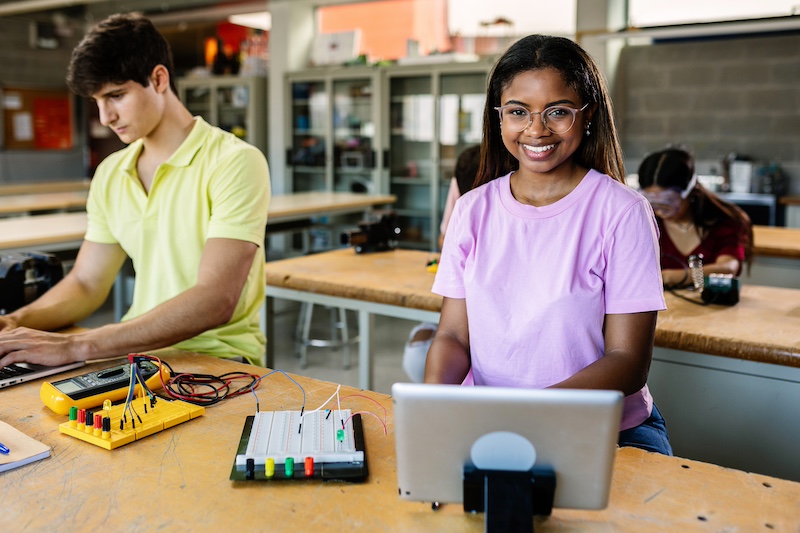 Portrait of smiling hispanic latin student woman at technology class