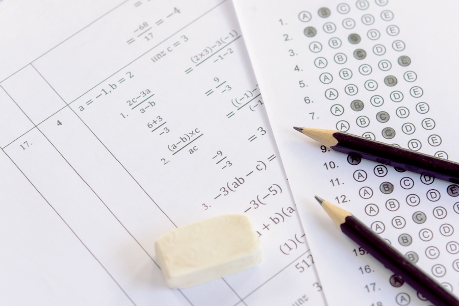 Pencil and eraser on answer sheets or Standardized test form with answers bubbled. multiple choice answer sheet