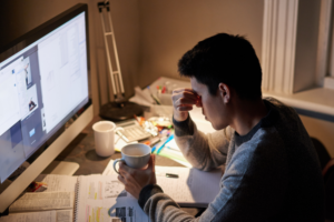 College student stressed while studying late at night, illustrating the uncertainty and challenges of being deferred by top colleges during the admissions process