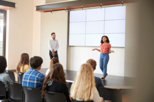 High school students giving a presentation at a summer business and entrepreneurship program.