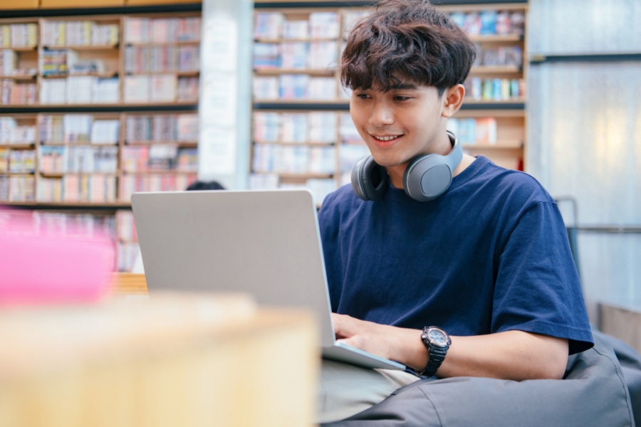 High school student working on a laptop in a library, preparing research for IEEE publication.