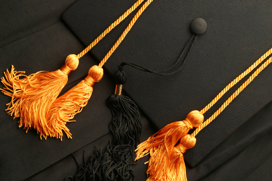 A close-up of a graduation cap with honor cords and tassels, symbolizing high school academic achievements.