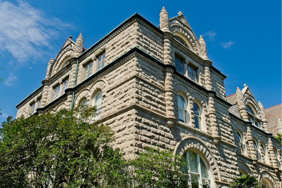 Historic Gibson Hall stone building at Tulane University under a bright blue sky, representing Tulane’s Pathway to Medicine program.